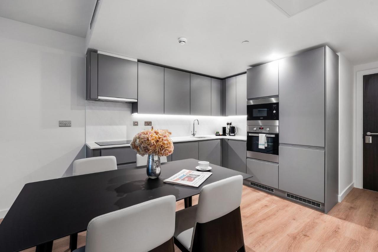 Citysuites 2 Aparthotel Μάντσεστερ Εξωτερικό φωτογραφία The photo shows a modern kitchen space. It features sleek, gray cabinetry with a minimalist design. There is a countertop with a sink, and appliances including an oven and a coffee maker. A dining table is positioned near the kitchen area, accompanie